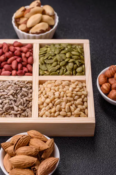 Organik sağlıklı yiyecekler için bir kutu fıstık, sedir fıstığı, ayçiçeği ve balkabağı çekirdeği.