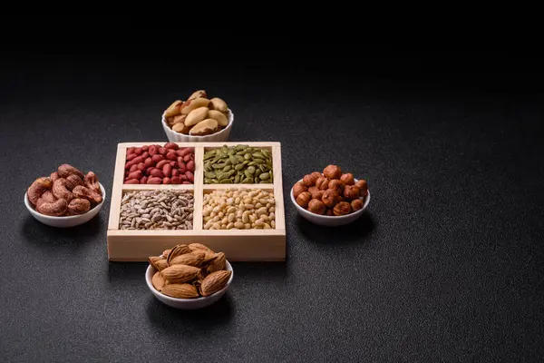 Organik sağlıklı yiyecekler için bir kutu fıstık, sedir fıstığı, ayçiçeği ve balkabağı çekirdeği.