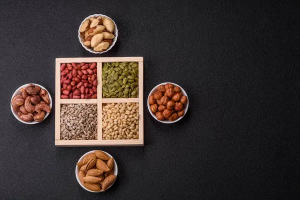 Organik sağlıklı yiyecekler için bir kutu fıstık, sedir fıstığı, ayçiçeği ve balkabağı çekirdeği.