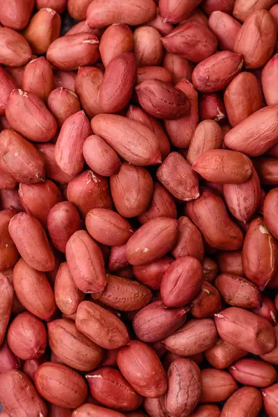 Koyu beton arka planda bir kasede yer fıstığı ya da kabuğu soyulmuş graundnut. Protein kaynağı olarak fındık