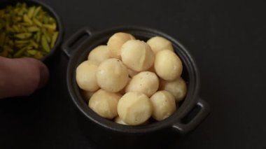 Koyu beton arka planda seramik kasede soyulmuş macadamia cevizi. Besin kaynağı olarak fındık