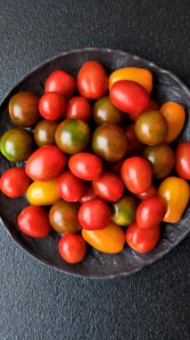 Sebze yemeği olarak farklı renkte domatesler. Çeri domateslerinden oluşan çok renkli bir arkaplan