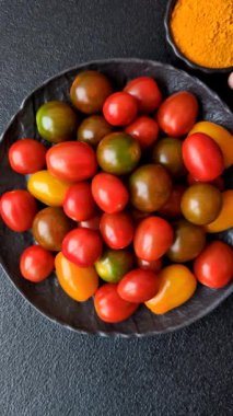 Sebze yemeği olarak farklı renkte domatesler. Çeri domateslerinden oluşan çok renkli bir arkaplan