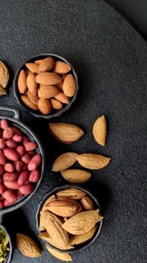 Koyu beton arka planda bir kasede yer fıstığı ya da kabuğu soyulmuş graundnut. Protein kaynağı olarak fındık