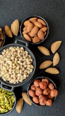 Koyu beton arka planda bir kasede soyulmuş çam fıstığı. Protein kaynağı olarak fındık.