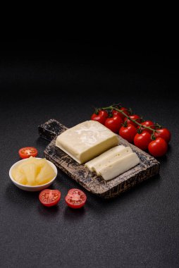 Süt beyazı mozarella peyniri domatesli caprese salatası için bir malzeme olarak dilimlenmiş.