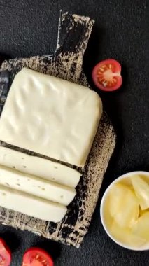 Süt beyazı mozarella peyniri domatesli caprese salatası için bir malzeme olarak dilimlenmiş.