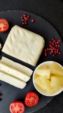 Süt beyazı mozarella peyniri domatesli caprese salatası için bir malzeme olarak dilimlenmiş.