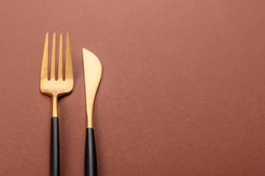 Bıçak ve çatal, kahverengi yemek masasında çatal bıçak takımı. Akşam yemeğini hazırlamak için alet edevat ve çanak çömlek.