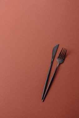 Bıçak ve çatal, kahverengi yemek masasında çatal bıçak takımı. Akşam yemeğini hazırlamak için alet edevat ve çanak çömlek.