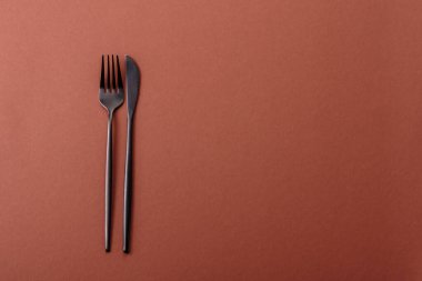 Bıçak ve çatal, kahverengi yemek masasında çatal bıçak takımı. Akşam yemeğini hazırlamak için alet edevat ve çanak çömlek.