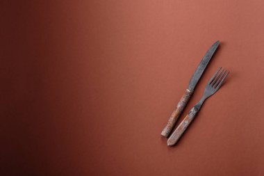 Bıçak ve çatal, kahverengi yemek masasında çatal bıçak takımı. Akşam yemeğini hazırlamak için alet edevat ve çanak çömlek.