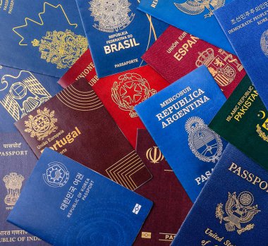 Farklı ülkelerin vatandaşlarının pasaportları, çeşitli ülkelerin pasaportlarından oluşan arka plan..