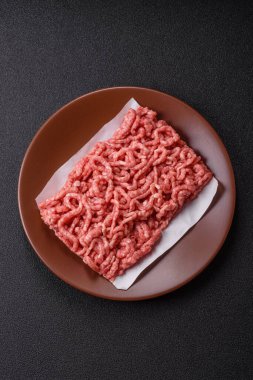 Siyah bir zemin üzerinde tuz ve baharatla doldurulmuş çiğ et ya da domuz eti.