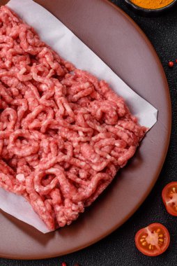 Siyah bir zemin üzerinde tuz ve baharatla doldurulmuş çiğ et ya da domuz eti.