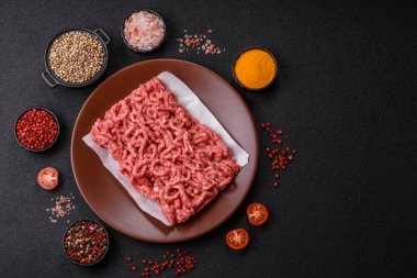 Siyah bir zemin üzerinde tuz ve baharatla doldurulmuş çiğ et ya da domuz eti.