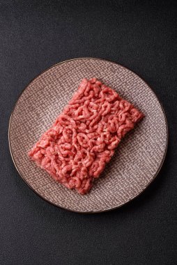 Siyah bir zemin üzerinde tuz ve baharatla doldurulmuş çiğ et ya da domuz eti.