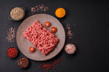 Siyah bir zemin üzerinde tuz ve baharatla doldurulmuş çiğ et ya da domuz eti.