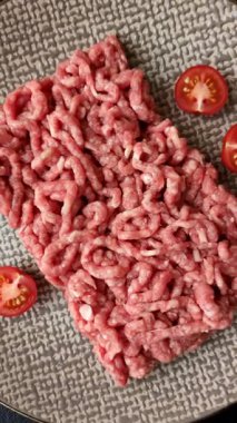 Siyah bir zemin üzerinde tuz ve baharatla doldurulmuş çiğ et ya da domuz eti.