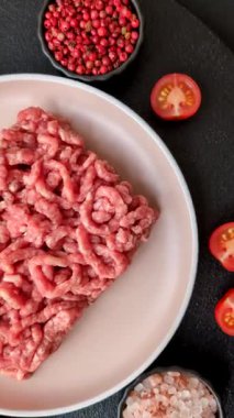 Siyah bir zemin üzerinde tuz ve baharatla doldurulmuş çiğ et ya da domuz eti.