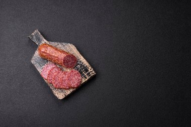 Dilimlenmiş salam sosisi, tütsülenmiş et, tabakta lezzetli mezeler.