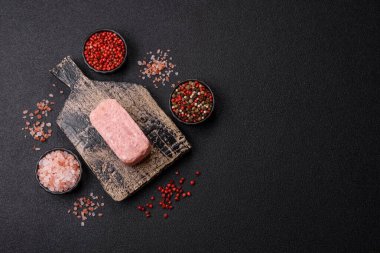 Konserve jambon, et, domuz eti, baharat ve tuzlu, koyu beton arka planda dilimler.