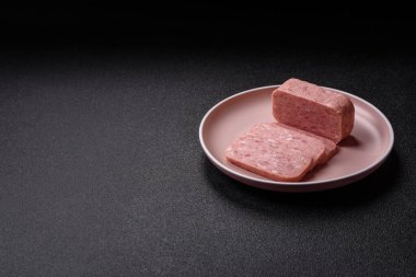 Konserve jambon, et, domuz eti, baharat ve tuzlu, koyu beton arka planda dilimler.
