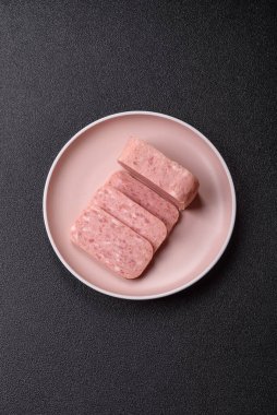 Konserve jambon, et, domuz eti, baharat ve tuzlu, koyu beton arka planda dilimler.