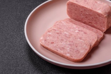 Konserve jambon, et, domuz eti, baharat ve tuzlu, koyu beton arka planda dilimler.