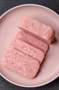 Konserve jambon, et, domuz eti, baharat ve tuzlu, koyu beton arka planda dilimler.