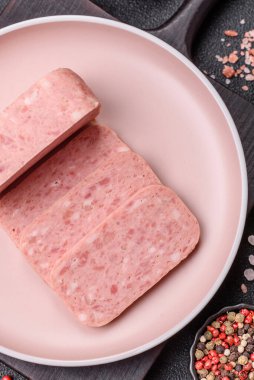 Konserve jambon, et, domuz eti, baharat ve tuzlu, koyu beton arka planda dilimler.