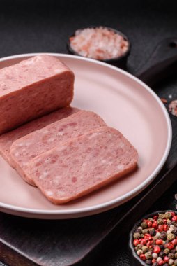 Konserve jambon, et, domuz eti, baharat ve tuzlu, koyu beton arka planda dilimler.