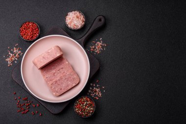 Konserve jambon, et, domuz eti, baharat ve tuzlu, koyu beton arka planda dilimler.