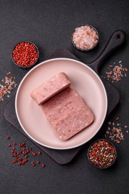 Konserve jambon, et, domuz eti, baharat ve tuzlu, koyu beton arka planda dilimler.