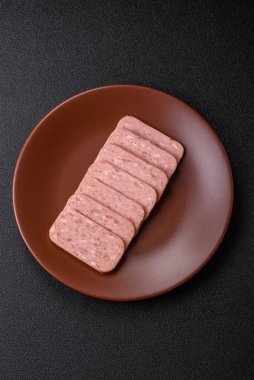 Konserve jambon, et, domuz eti, baharat ve tuzlu, koyu beton arka planda dilimler.