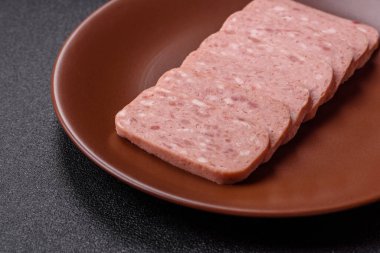 Konserve jambon, et, domuz eti, baharat ve tuzlu, koyu beton arka planda dilimler.
