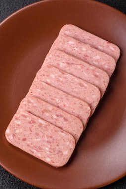 Konserve jambon, et, domuz eti, baharat ve tuzlu, koyu beton arka planda dilimler.