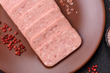 Konserve jambon, et, domuz eti, baharat ve tuzlu, koyu beton arka planda dilimler.