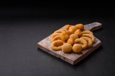 Yiyecek, tavuk nugget, soğan halkaları ve arka planda peynir topları. Fast food, sağlıksız yaşam tarzı