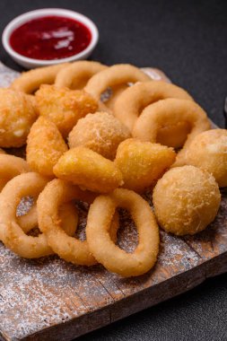 Yiyecek, tavuk nugget, soğan halkaları ve arka planda peynir topları. Fast food, sağlıksız yaşam tarzı