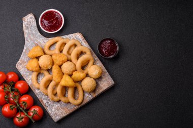 Yiyecek, tavuk nugget, soğan halkaları ve arka planda peynir topları. Fast food, sağlıksız yaşam tarzı