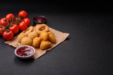 Yiyecek, tavuk nugget, soğan halkaları ve arka planda peynir topları. Fast food, sağlıksız yaşam tarzı