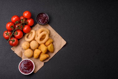 Yiyecek, tavuk nugget, soğan halkaları ve arka planda peynir topları. Fast food, sağlıksız yaşam tarzı
