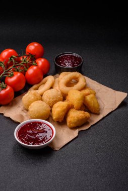 Yiyecek, tavuk nugget, soğan halkaları ve arka planda peynir topları. Fast food, sağlıksız yaşam tarzı