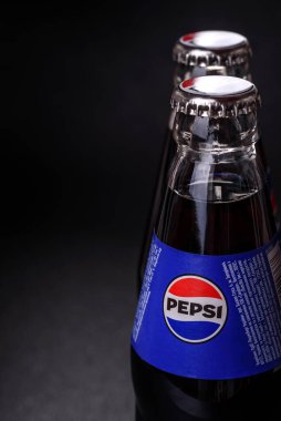 Nikopol, Dnepropetrovsk bölgesi Ukrayna - 24 Nisan 2025: Siyah arka planda bir şişe soğutulmuş pepsi. Sıcak bir yaz gününde serin bir içecek.