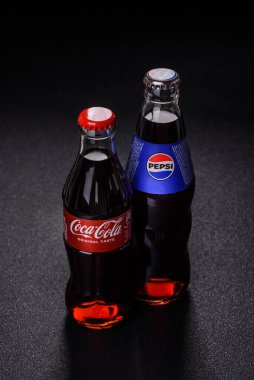 Nikopol, Dnepropetrovsk bölgesi Ukrayna - 24 Nisan 2025: Siyah arka planda bir şişe soğutulmuş kola ve pepsi. Sıcak bir yaz gününde serin bir içecek.