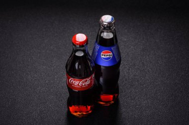 Nikopol, Dnepropetrovsk bölgesi Ukrayna - 24 Nisan 2025: Siyah arka planda bir şişe soğutulmuş kola ve pepsi. Sıcak bir yaz gününde serin bir içecek.