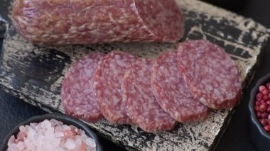 Dilimlenmiş salam sosisi, tütsülenmiş et, tabakta lezzetli mezeler.