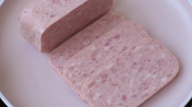 Konserve jambon, et, domuz eti, baharat ve tuzlu, koyu beton arka planda dilimler.