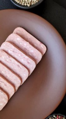 Konserve jambon, et, domuz eti, baharat ve tuzlu, koyu beton arka planda dilimler.